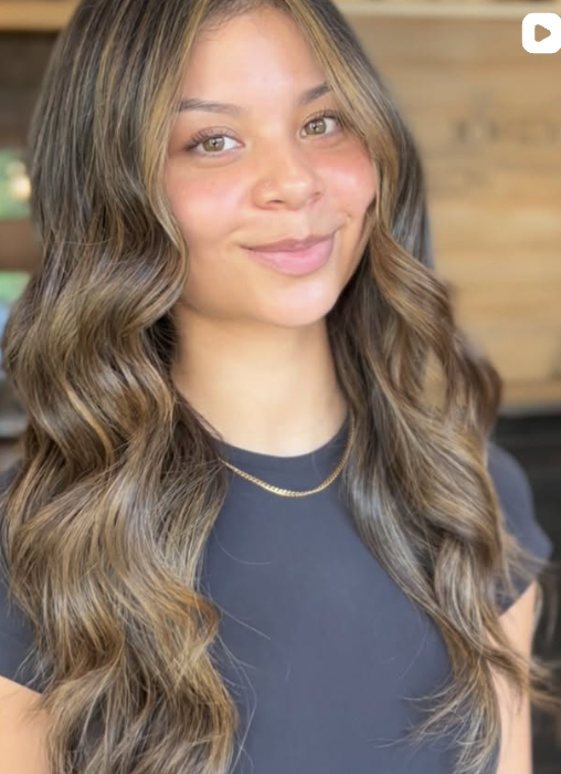 Dimensional brunette waves with soft glossy highlights.
