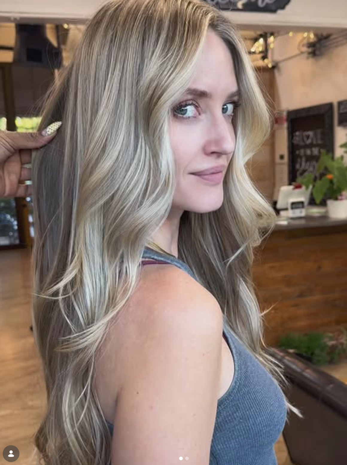 Client result with long blended blonde color and flowing polished waves.
